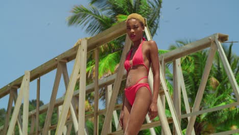 In-the-midst-of-tropical-beauty,-a-girl-with-dark-skin-dons-a-red-bikini-on-a-Caribbean-white-sand-beach