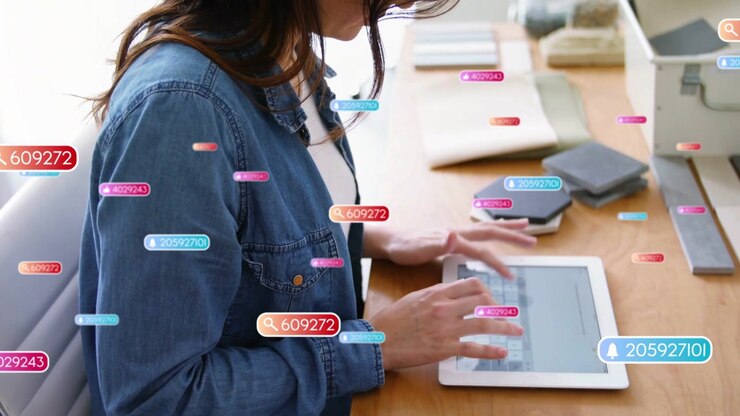 Woman typing on tablet, generating floating tags circling hands and desk, creating marketing copy