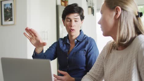 Caucasian-lesbian-couple-calculating-finances-together-using-laptop-at-home