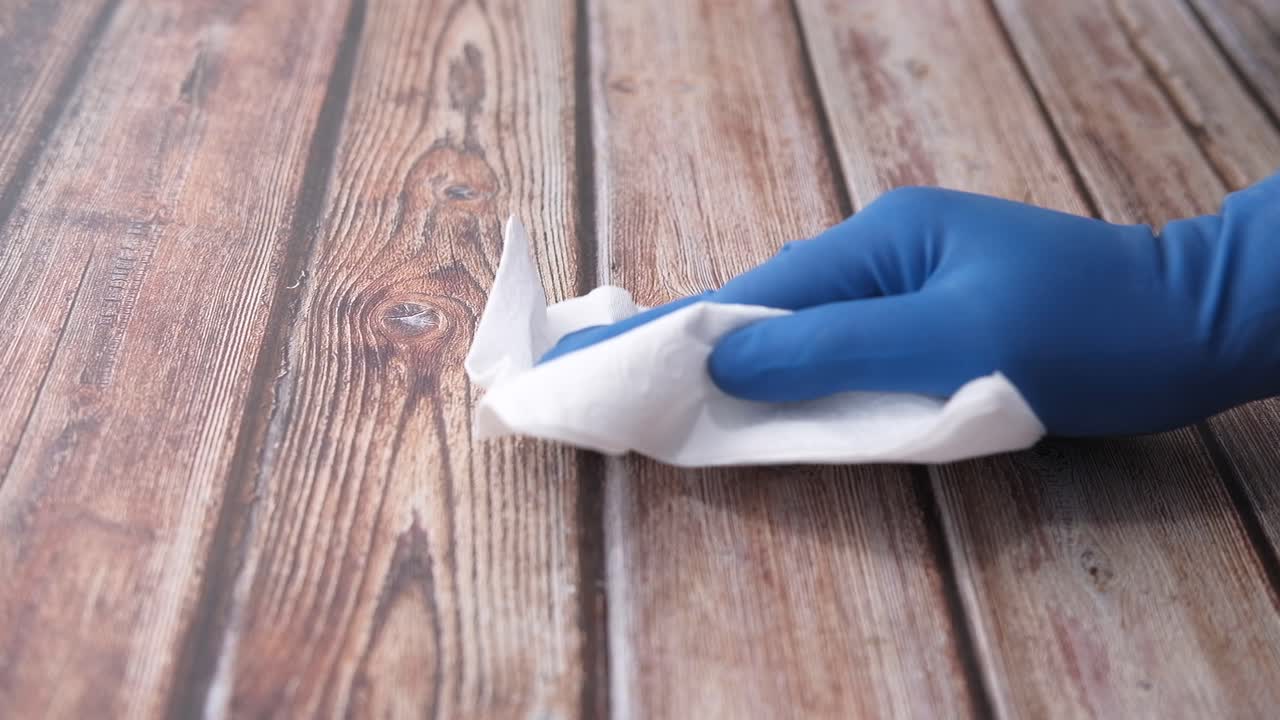 limpiando una mesa de madera con guantes