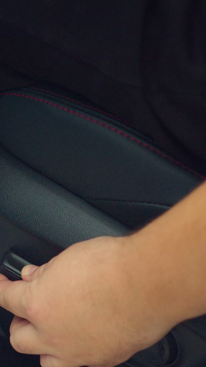 Mano ajustando la palanca del asiento en un vehículo moderno