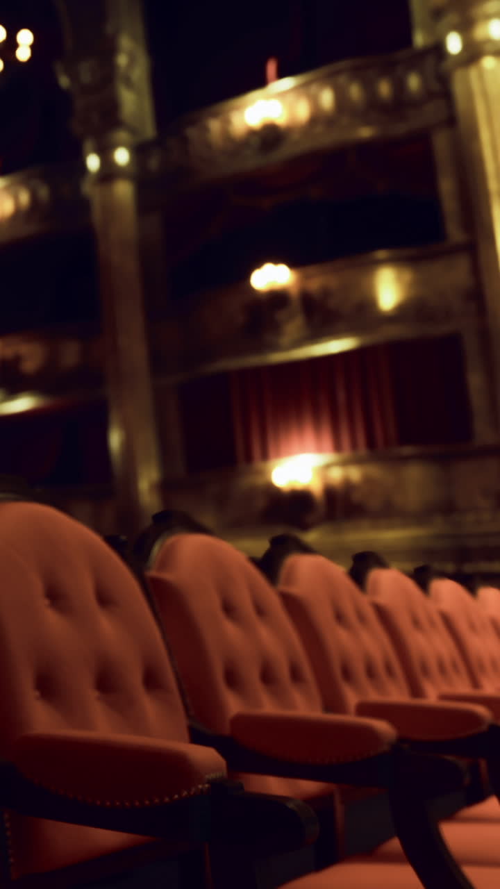Posti vuoti in un teatro durante uno spettacolo serale in una location imponente.