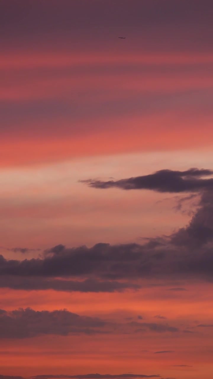 Airplane Flying Across a Vibrant Sunset Sky