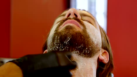 peluquero aplicando crema de afeitar en el salón de belleza 4k