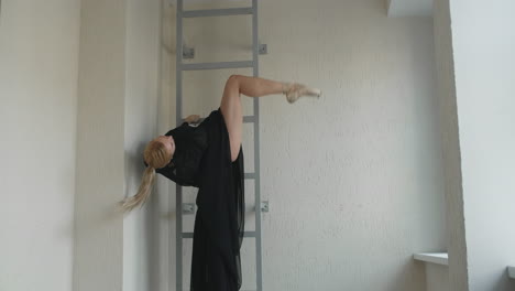 ballet dancer stretching on a metal ladder