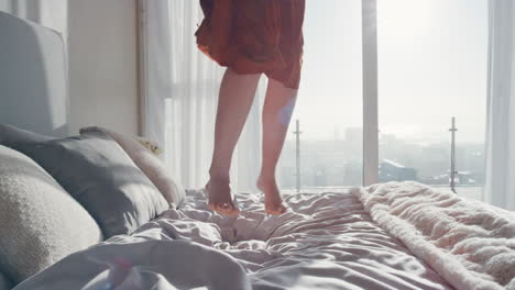 mujer feliz saltando en la cama en una habitación de hotel divirtiéndose estilo de vida exitoso celebrando disfrutando de un lujoso apartamento de ático