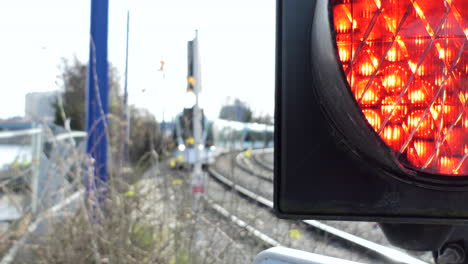 4k modern tram coming plus warning traffic light blinking red to warn of his arrival