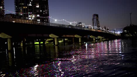 illuminated bridge reflecting on river at night