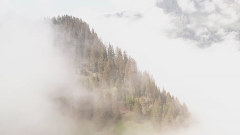 Aerial-of-mountain-top-rising-over-bright-clouds