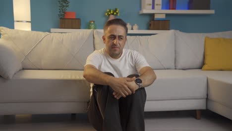 hombre deprimido. se sienta junto a la pared.