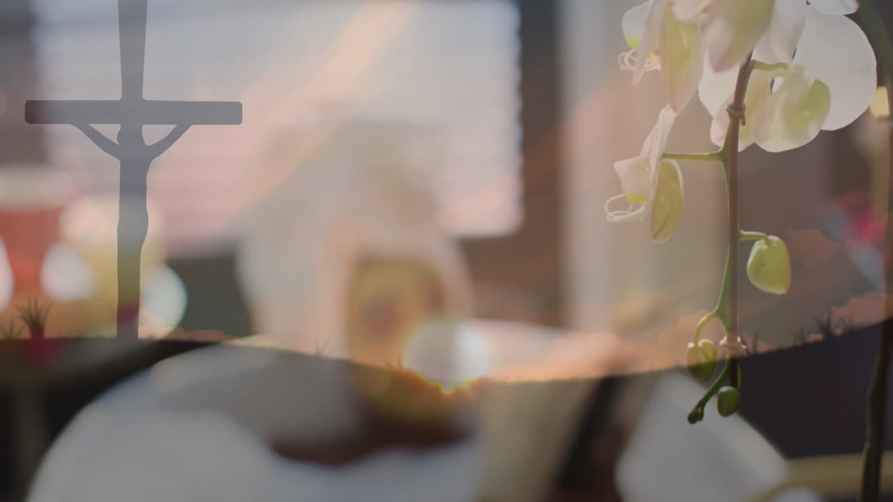 Relaxing with face mask, person reading book near orchid flowers and cross