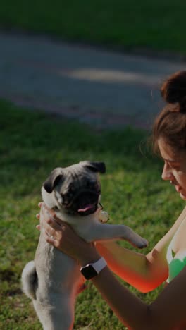 mujer con cachorro de pug en el parque