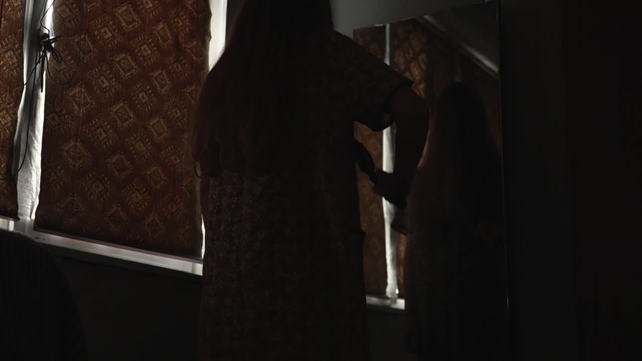 creepy woman staring into an antique mirror in a dark room. Perfect for Halloween intros, horror trailers, and eerie cinematic storytelling