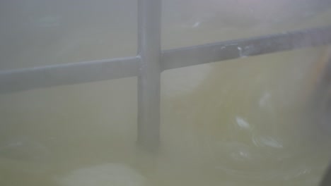 primer plano extremo del brazo mezclador dentro de una caldera industrial mientras se preparan delicias turcas