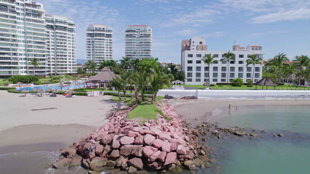 un rompeolas con césped y palmeras en la playa de puerto vallarta