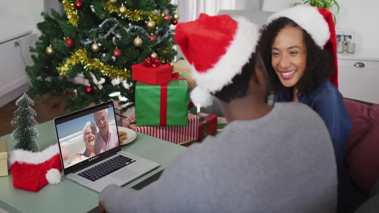 feliz pareja afroamericana en videollamada con pareja mayor en tiempo de navidad