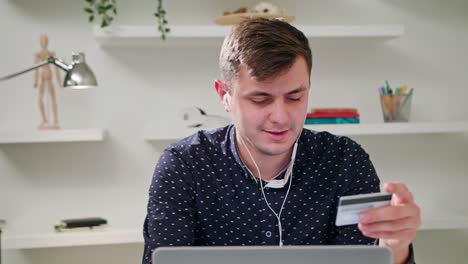 un joven usando una computadora portátil en el interior