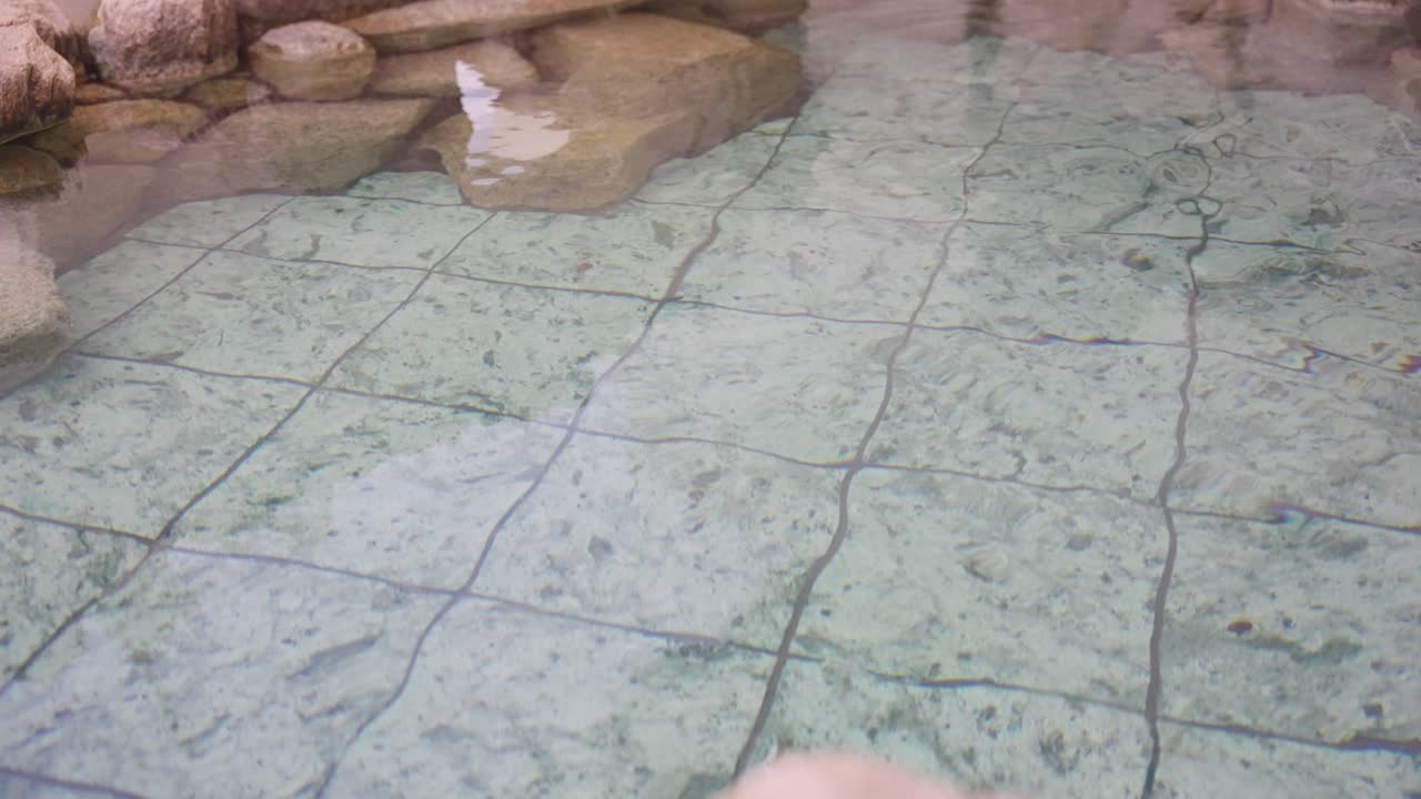 baños al aire libre de aguas termales, agua ondulante en cámara lenta 4k