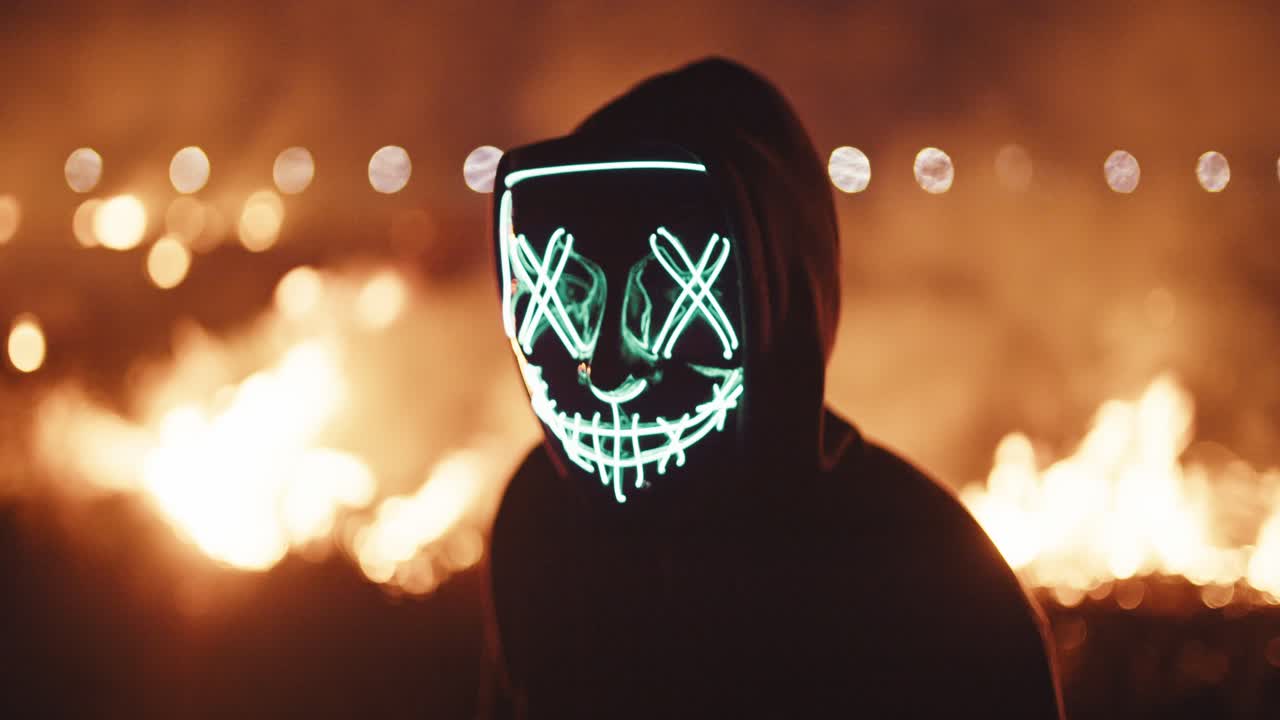 persona con máscara brillante en el espectáculo de fuego nocturno