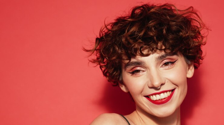 donna felice con i capelli ricci e le labbra rosse