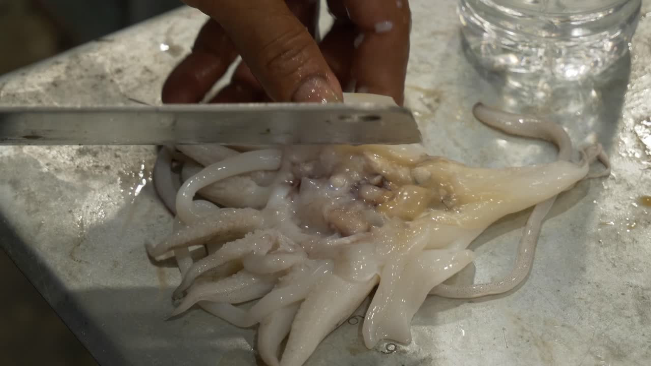 cutting processing cuttlefish on counter at local thailand street food restaurant for cooking