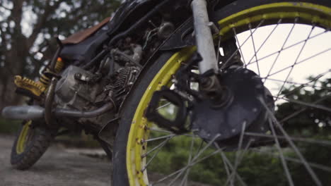 close up of wheels, rusty abandoned bike in rural outdoors