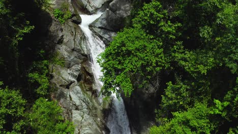 Panning-Up-a-Serene-Small-Section-of-the-Saltos-Jima-Waterfall-Falling-down-a-Cliffy-Rockside-surrounded-by-Green-Shrubs-in-Dominican-Republic