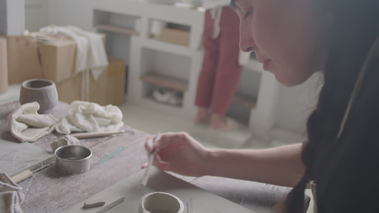 Woman Shaping Clay at Pottery Class in Artisan Studio