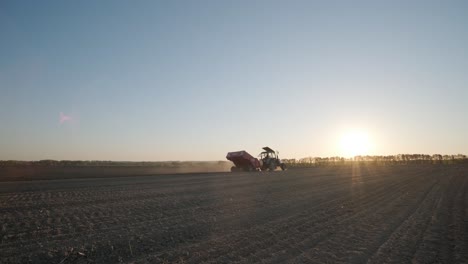 plantando un gran campo agrícola. el tractor vierte patatas en los agujeros. trabajo agrícola, agricultura.