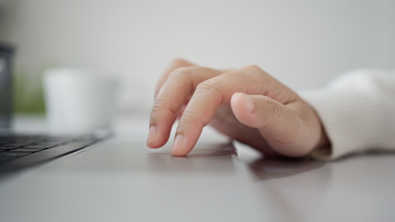 la mano de la mujer usa el trackpad, usando el touchpad en una computadora portátil, la persona de negocios trabajando escribiendo en una laptop.