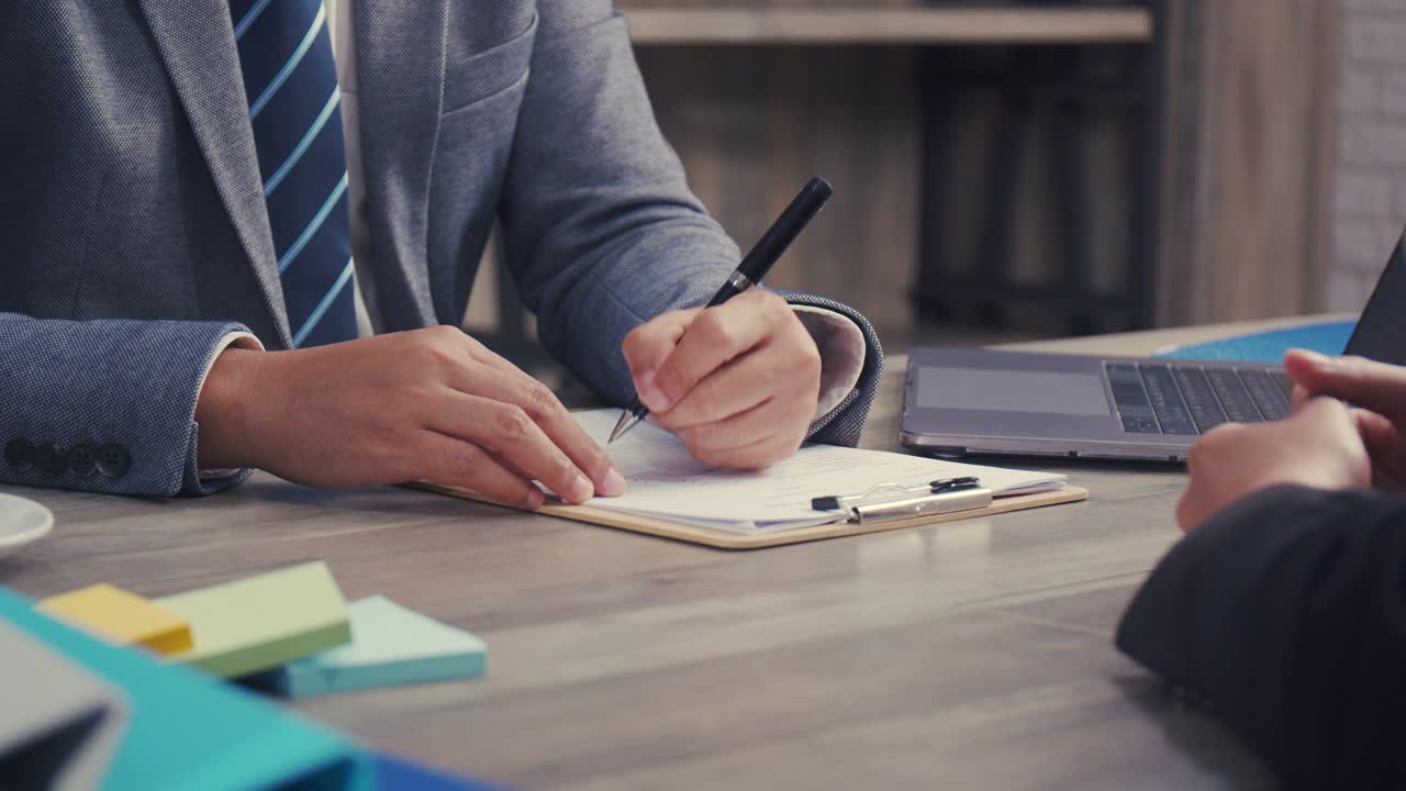 Job interview: Confident executive asking candidate question new employee and sign contract successful partnership deal at the office.