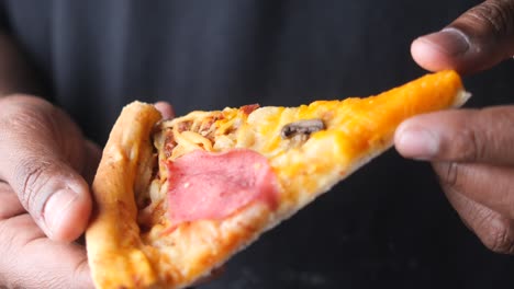 a piece of pizza in hands