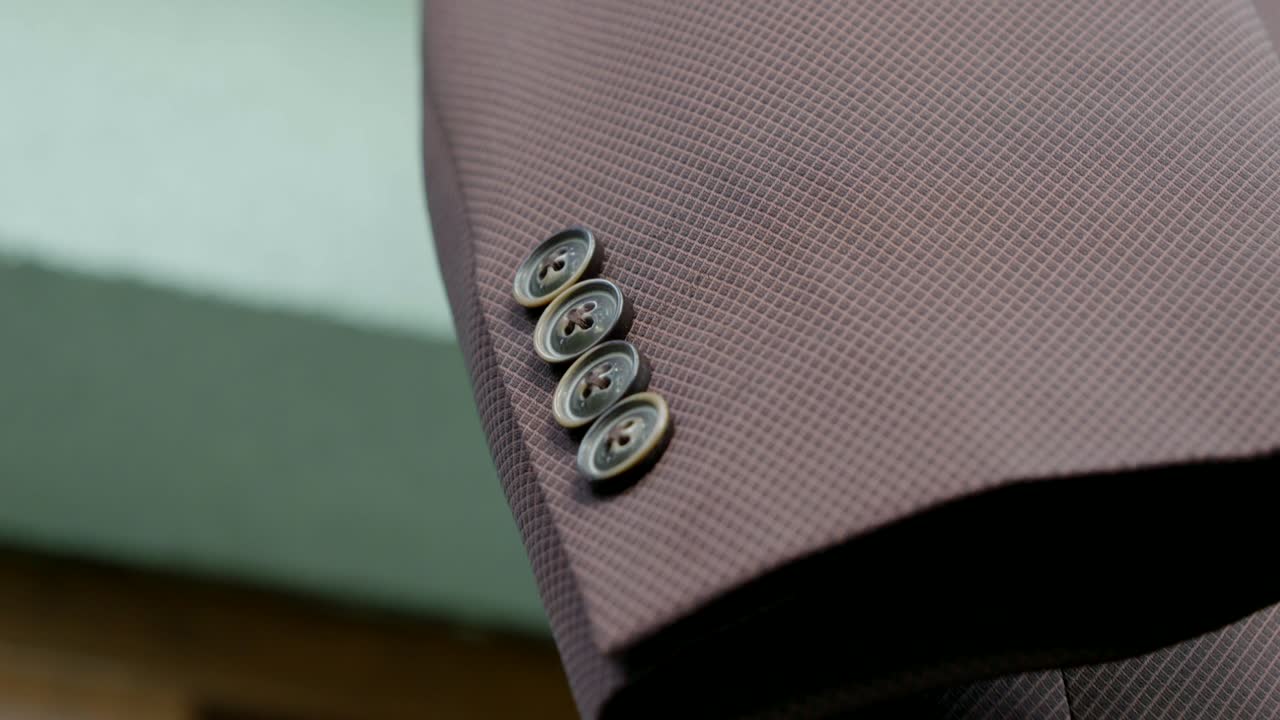 Close-up of the buttons on the groom's jacket, waiting for preparations for the wedding