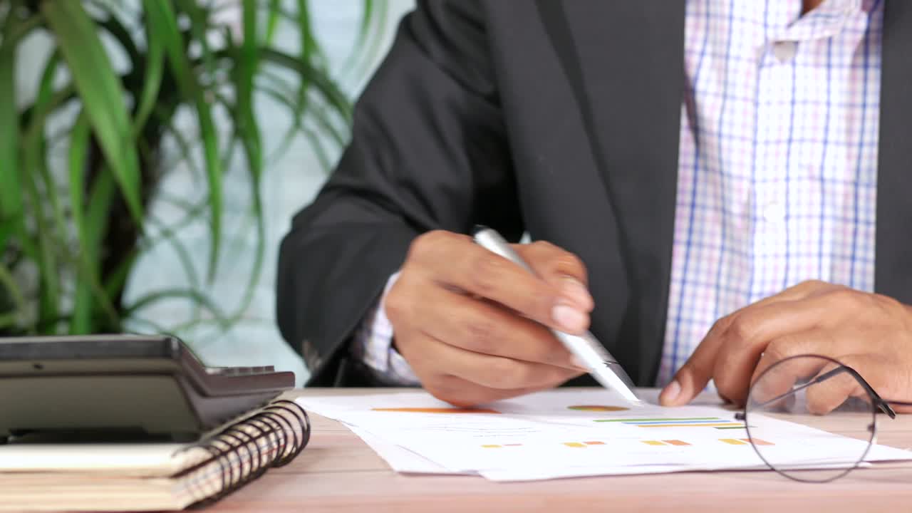 mano dell'uomo con la penna analizzando il grafico a barre su carta