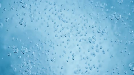 oxygen bubbles in water on a blue abstract background on super slow motion.