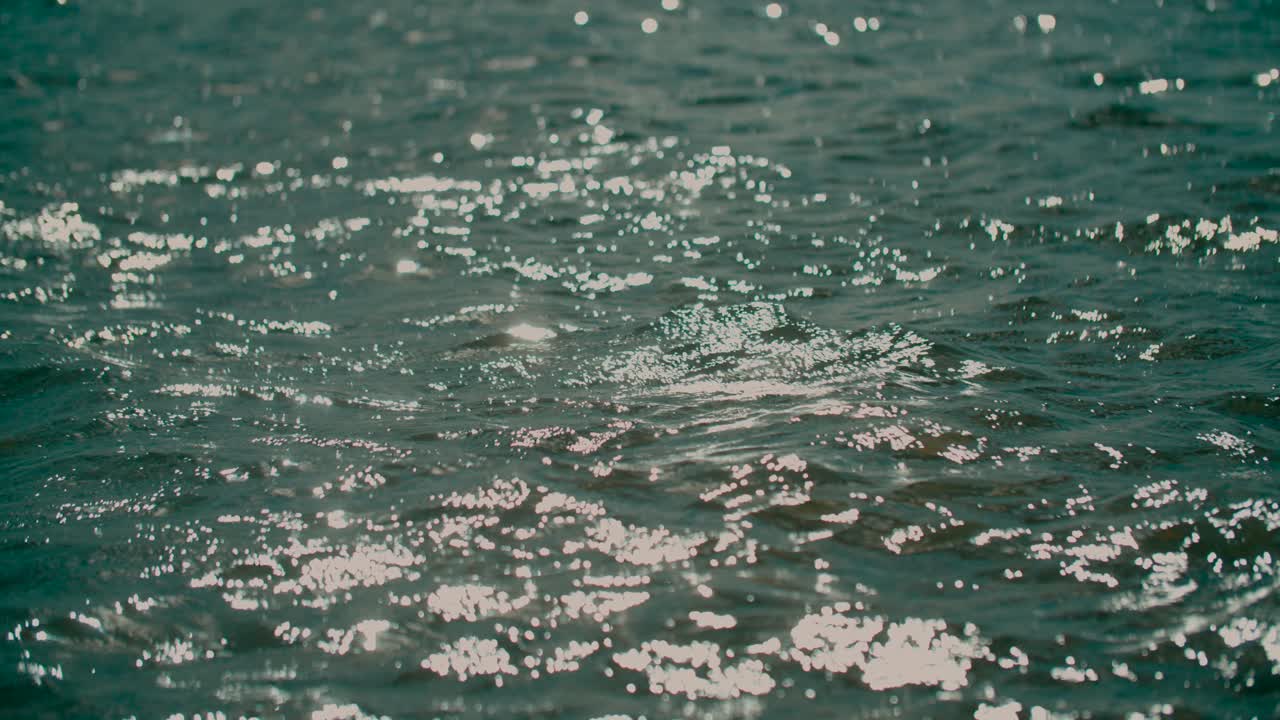 slow motion peaceful shimmering water peaks on cool clean lake in sunlight