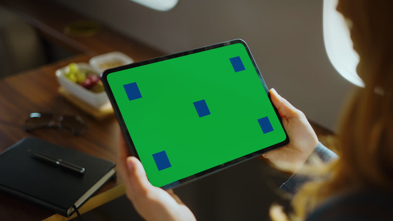Businesswoman Using Tablet with Green Screen on Private Jet