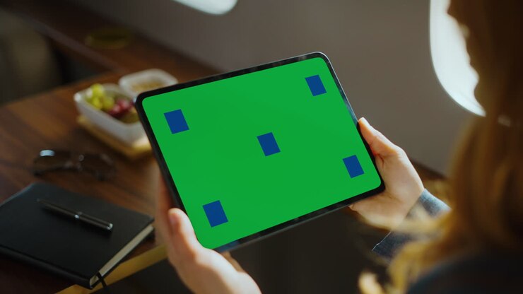 Imprenditrice che usa un tablet con schermo verde su un jet privato