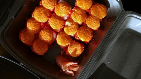 Rotating-view-looking-down-at-takeaway-sushi-in-a-polystyrene-box