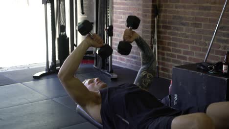 Músculos-De-Hombre-Tatuado-En-El-Gimnasio-En-Casa-Haciendo-Ejercicios-De-Pecho-Y-Tríceps-Con-Mancuernas-Hacia-Adentro