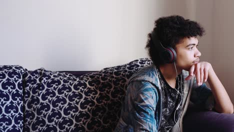 a mix race teen boy listens to music on headphones, medium shot