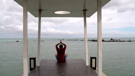 man is engaged in meditation by the sea