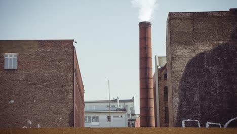 cinemagraph of smoke emitted from an industrial brick chimney in an old factory building