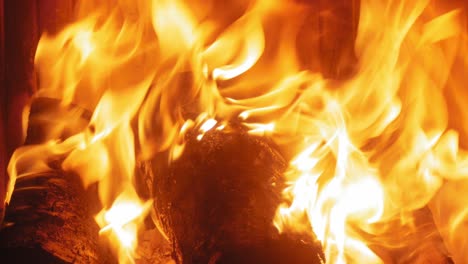 burning flame at fireplace on wooden logs