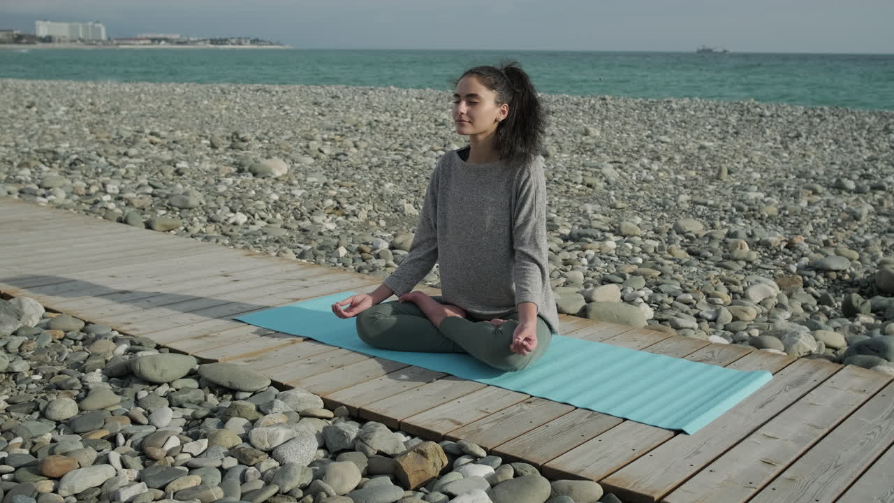 mujer meditando en una playa