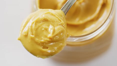 video of close up of jar of peanut butter on white background