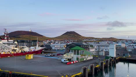 Vista-Temprano-En-La-Mañana-Del-Puerto-De-Vestmannaeyjar-Con-Barcos-Y-Edificios-Coloridos,-Clima-Tranquilo