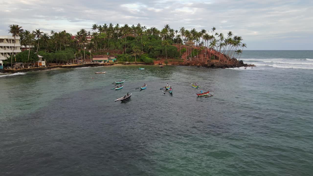 Pescatori locali su piccole imbarcazioni nella baia turistica di Mirissa, Sri Lanka, ripresa aerea.