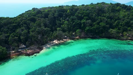 tropical island landscape with turquoise waters and dense forest beach cottage on koh wai island in thailand. beautiful aerial view flight descending drone