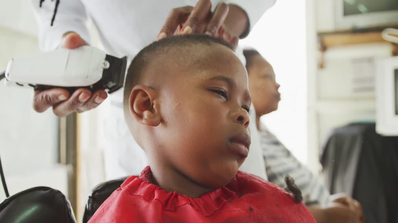 vista de cerca de un hombre africano cortando el cabello de un niño africano